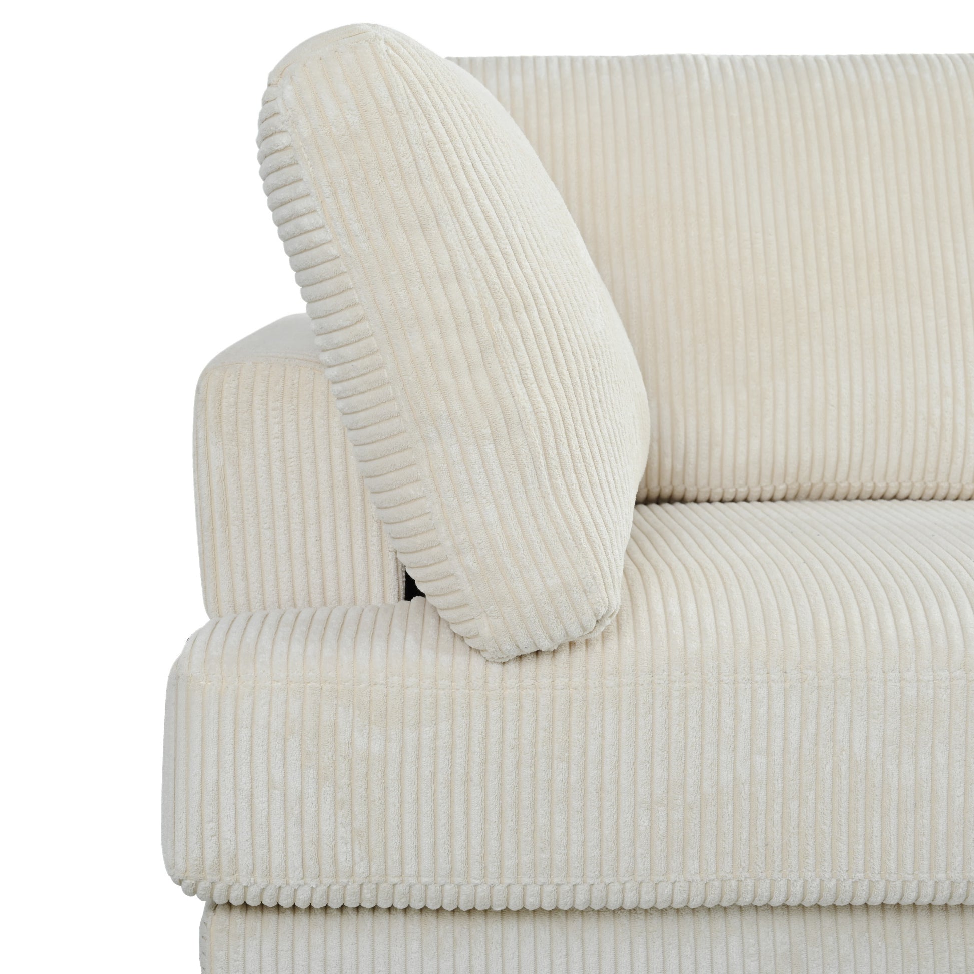 Closeup of a plush ivory corduroy sofa armrest with a matching cushion