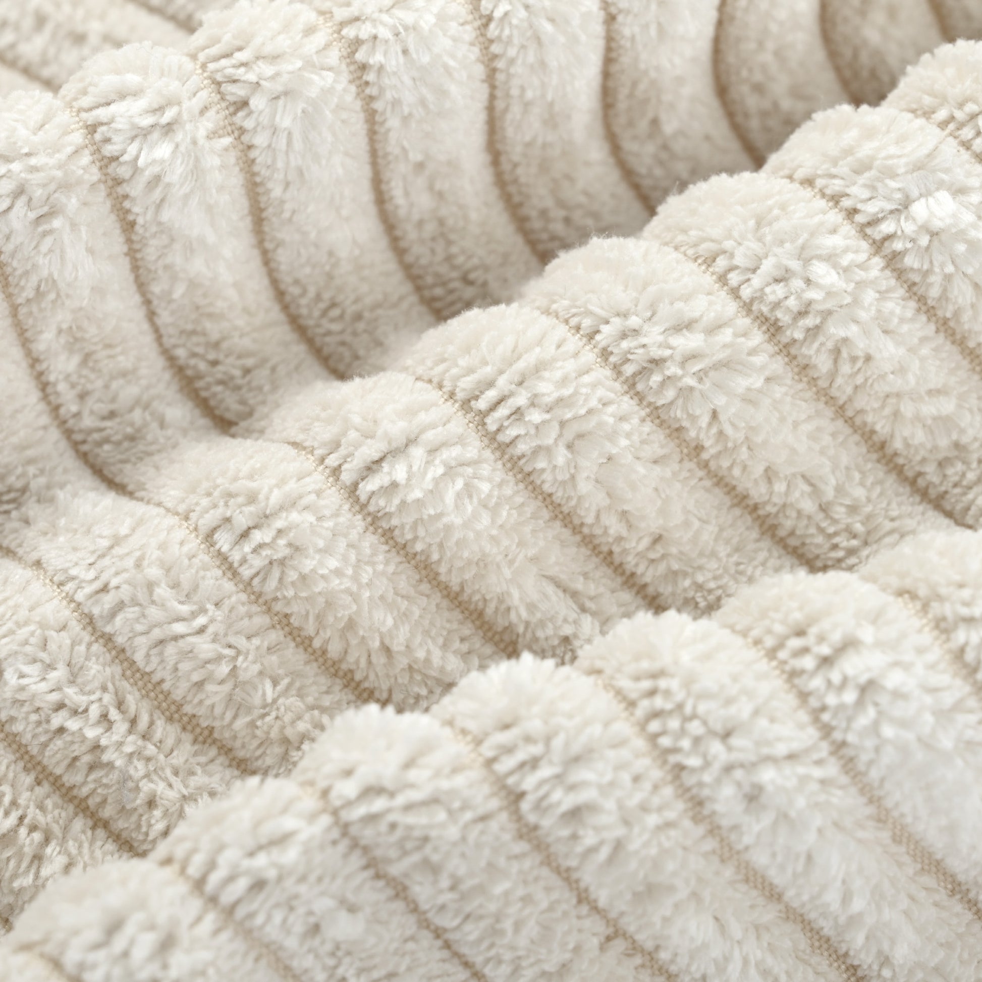Closeup of plush cream corduroy fabric texture with raised ridges