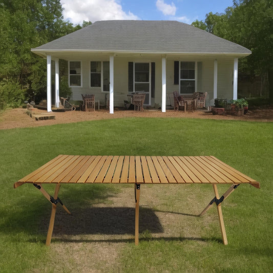 Portable wooden slatted camping table with foldable legs on grass