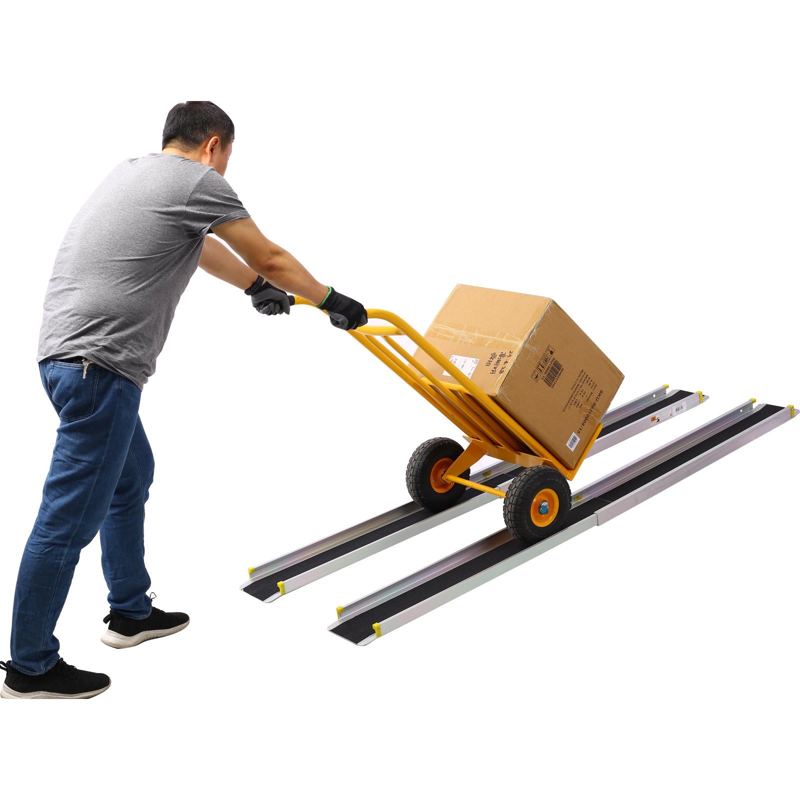 Man pushes yellow dolly with box on loading ramps