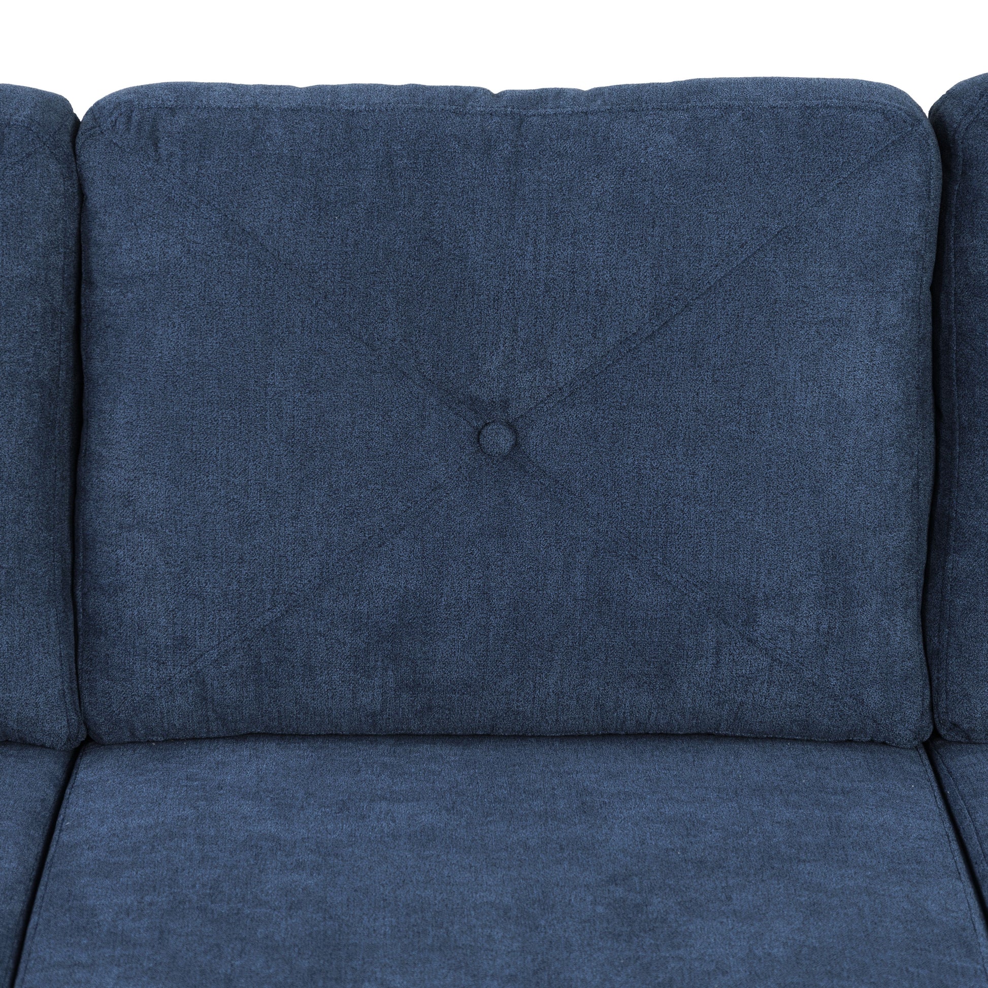 Closeup of a navy blue fabric sofa cushion with diamond stitching and a central button