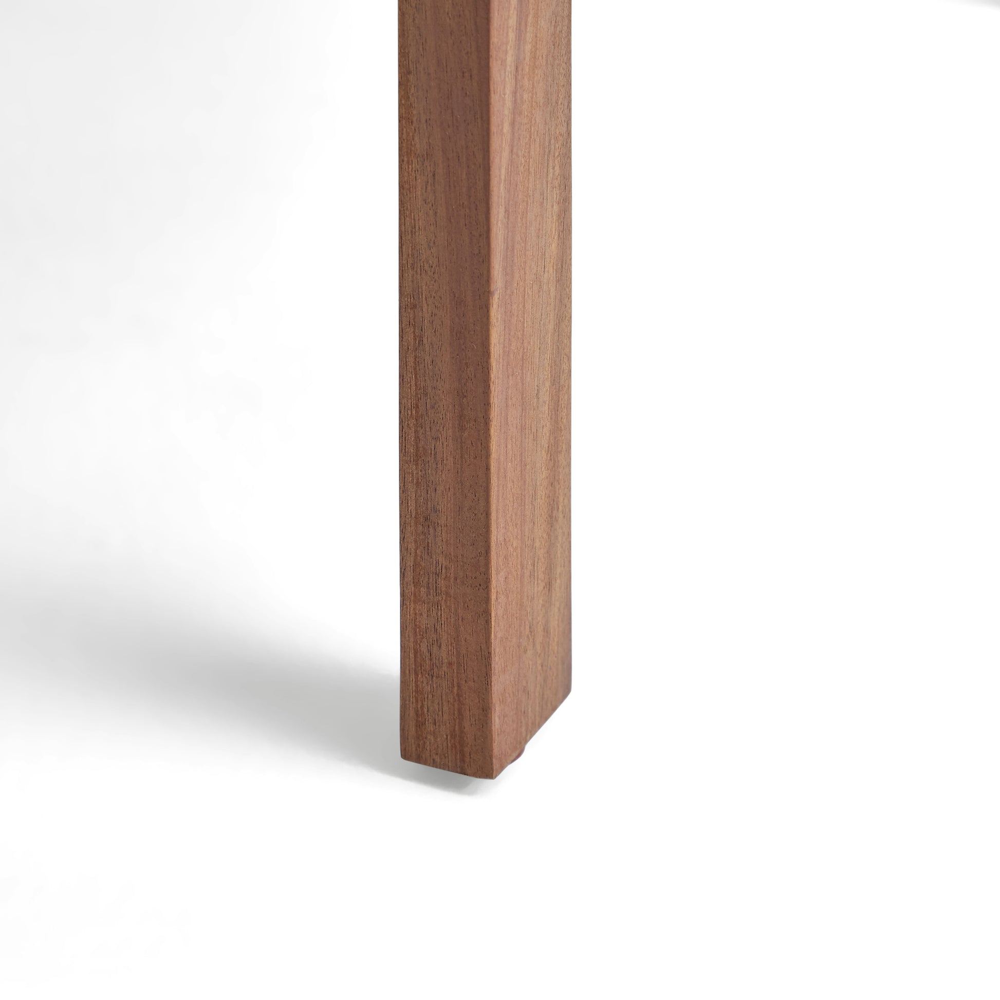 Closeup of a solid wood table leg with visible grain texture in natural light
