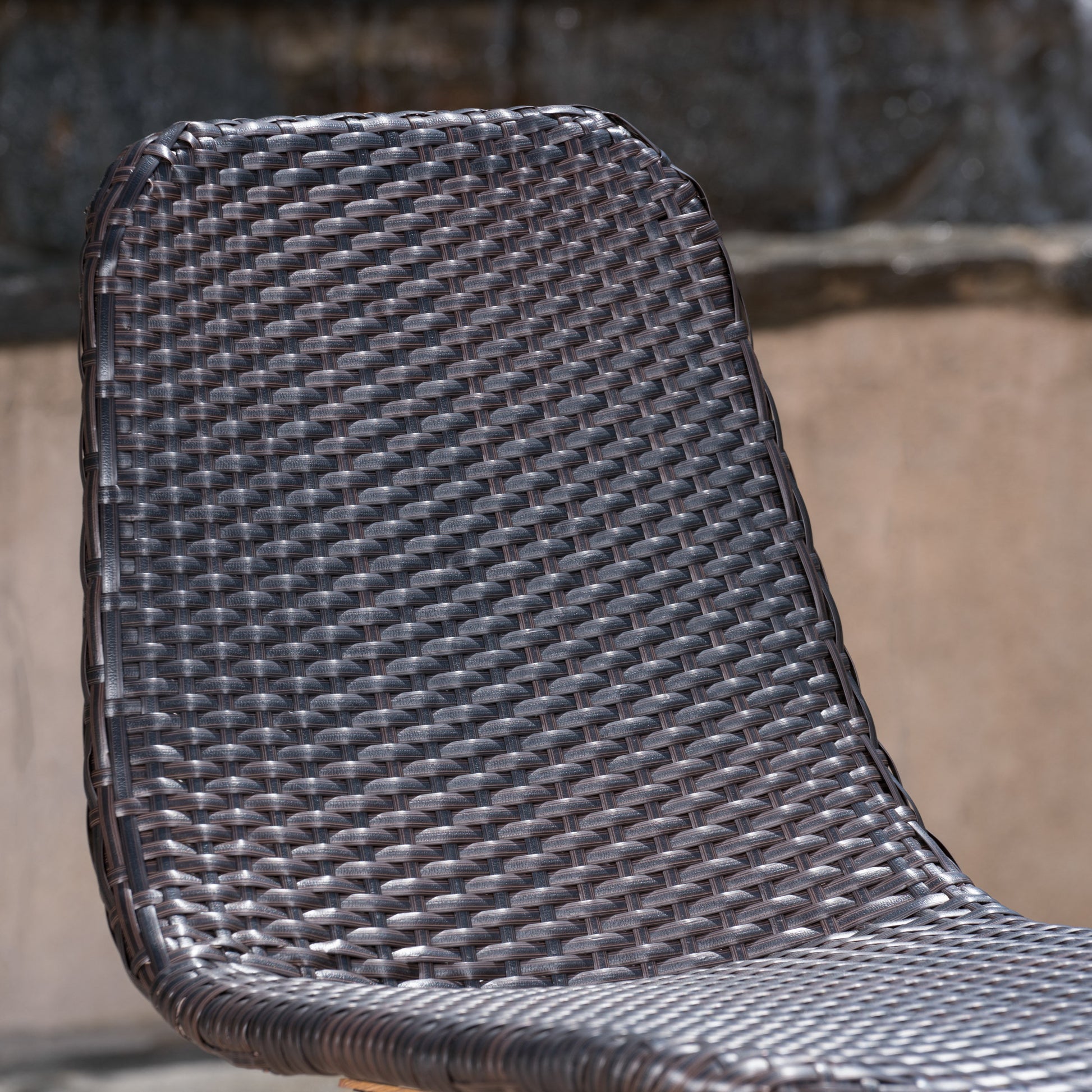 Closeup of a dark brown wicker outdoor chair with a woven texture