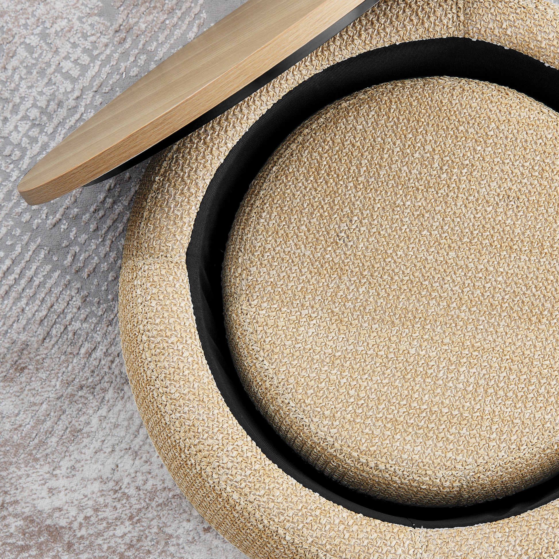 Round straw ottoman with natural weave and black piping detail