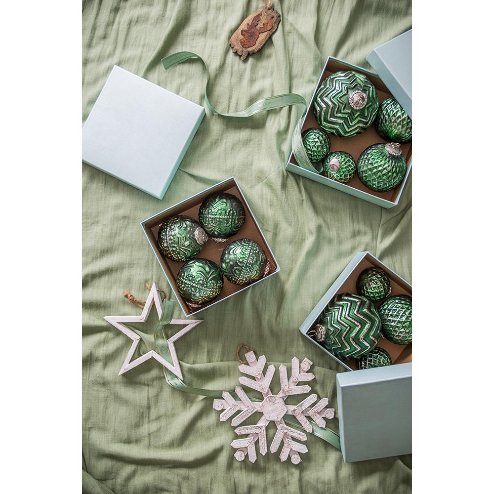 Set of four vintagestyle green glass Christmas ornaments with intricate patterns