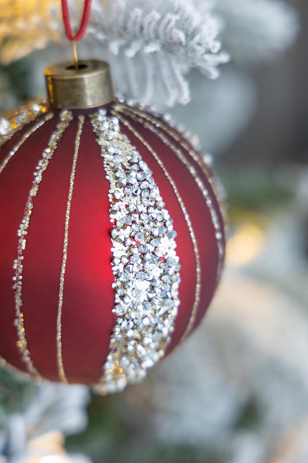 Red glass Christmas ornament with gold glitter stripes and crystal accents