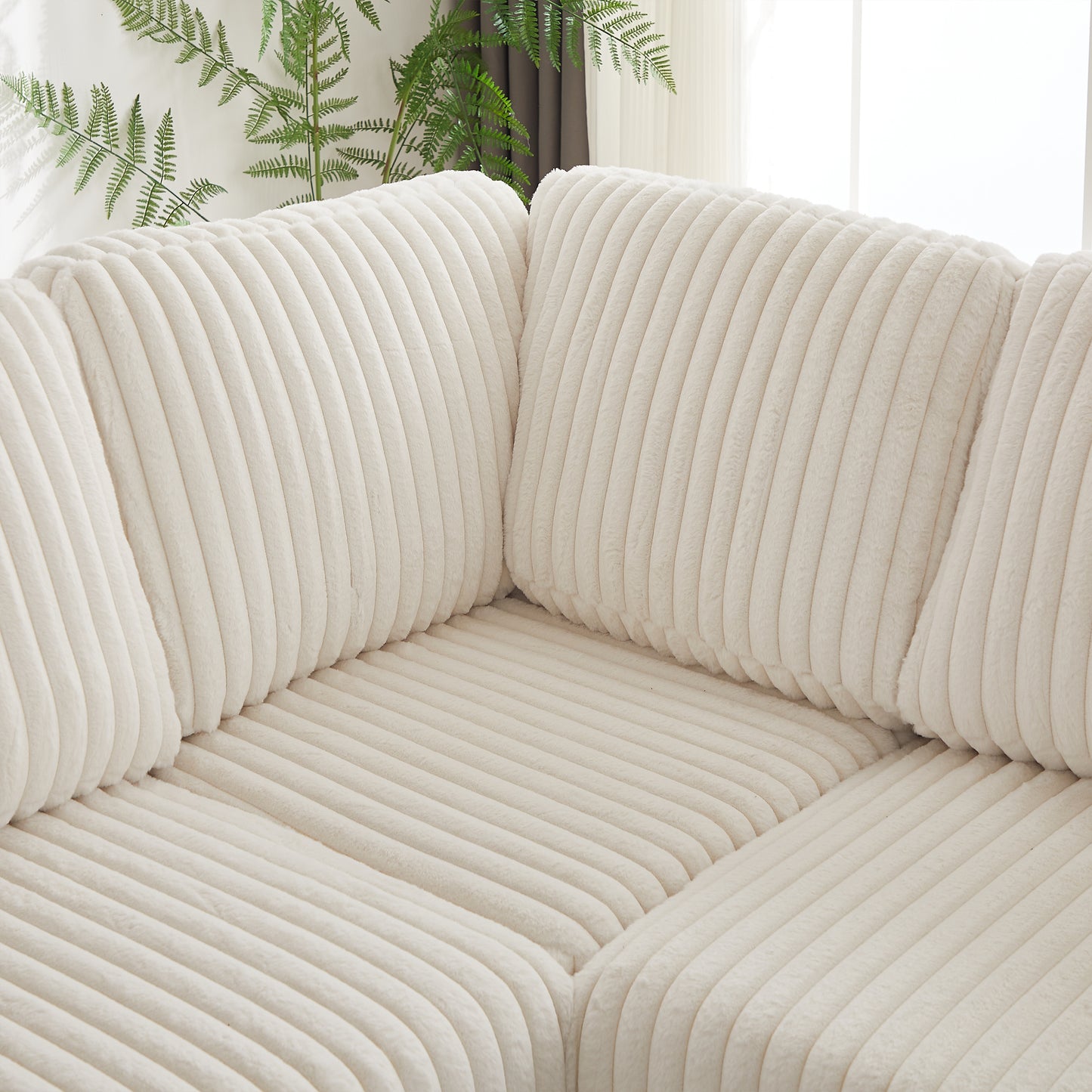 Closeup of plush cream corduroy sofa with channel tufting adding texture and comfort