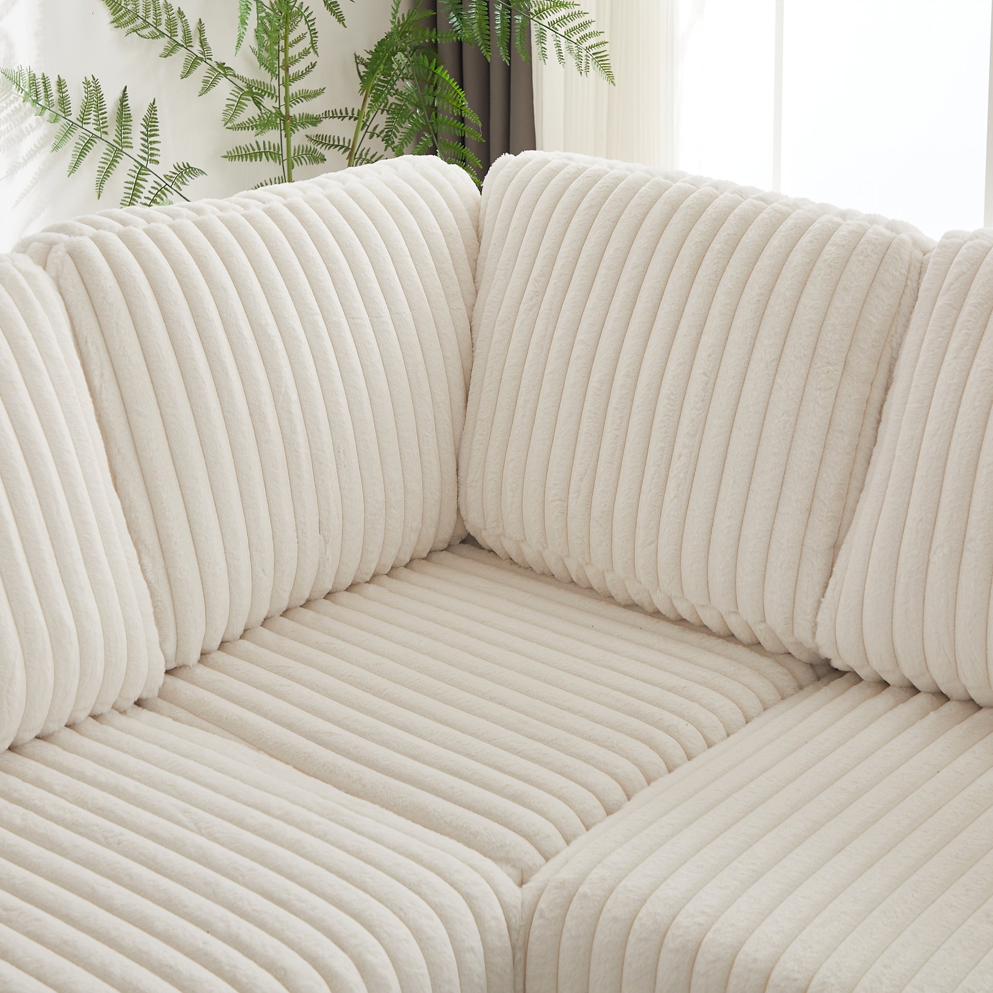 Closeup of plush cream corduroy sofa with channel tufting adding texture and comfort