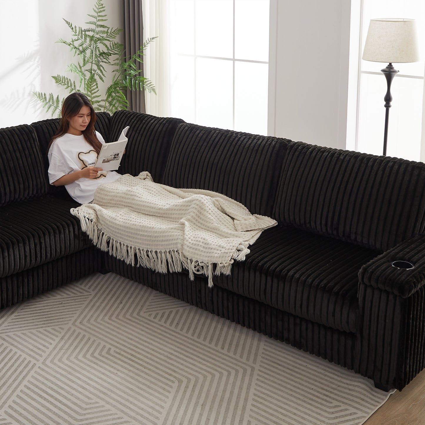 Textured dark gray sectional sofa with a builtin cup holder on armrest