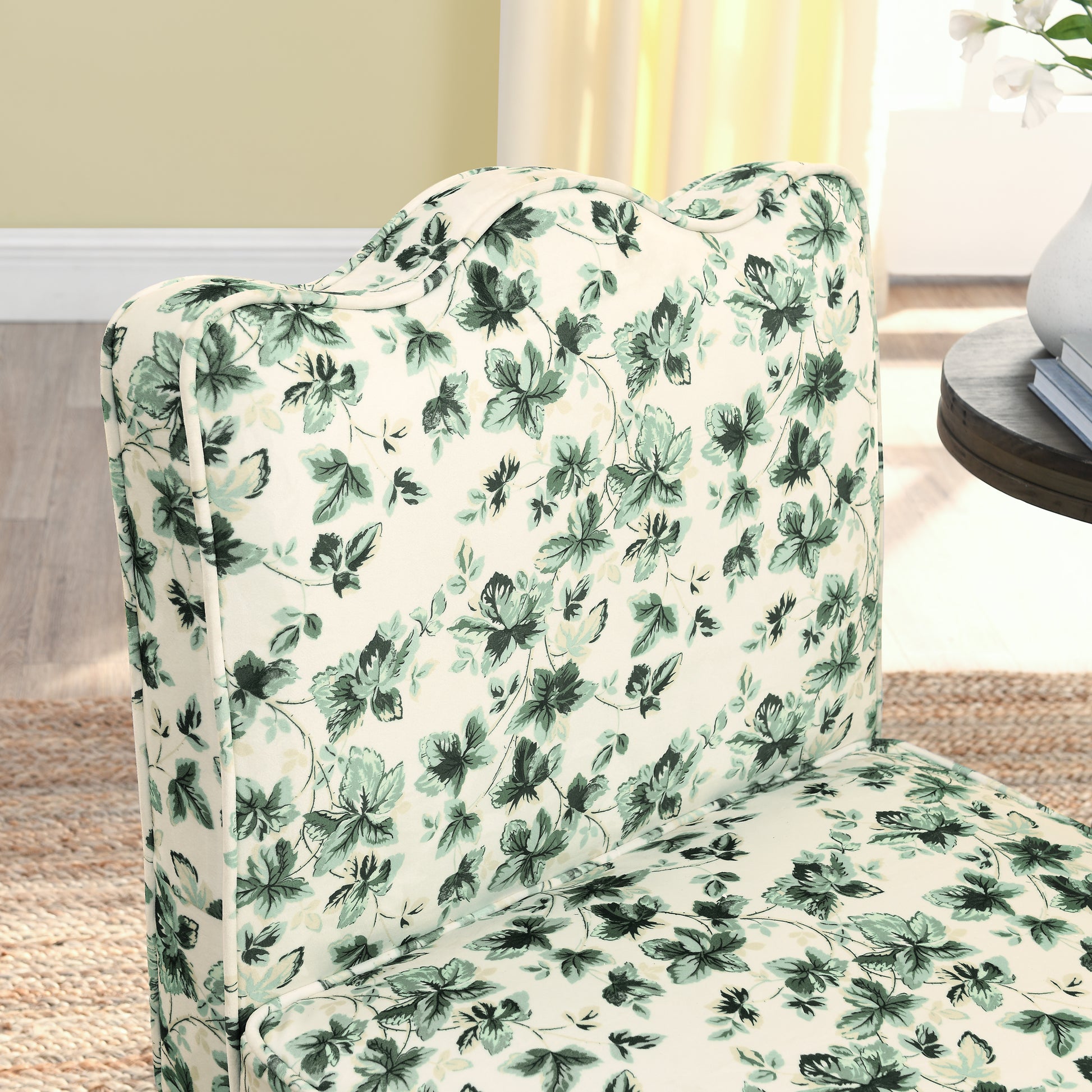 Cream accent chair with a vintage green floral print fabric featuring a scalloped backrest