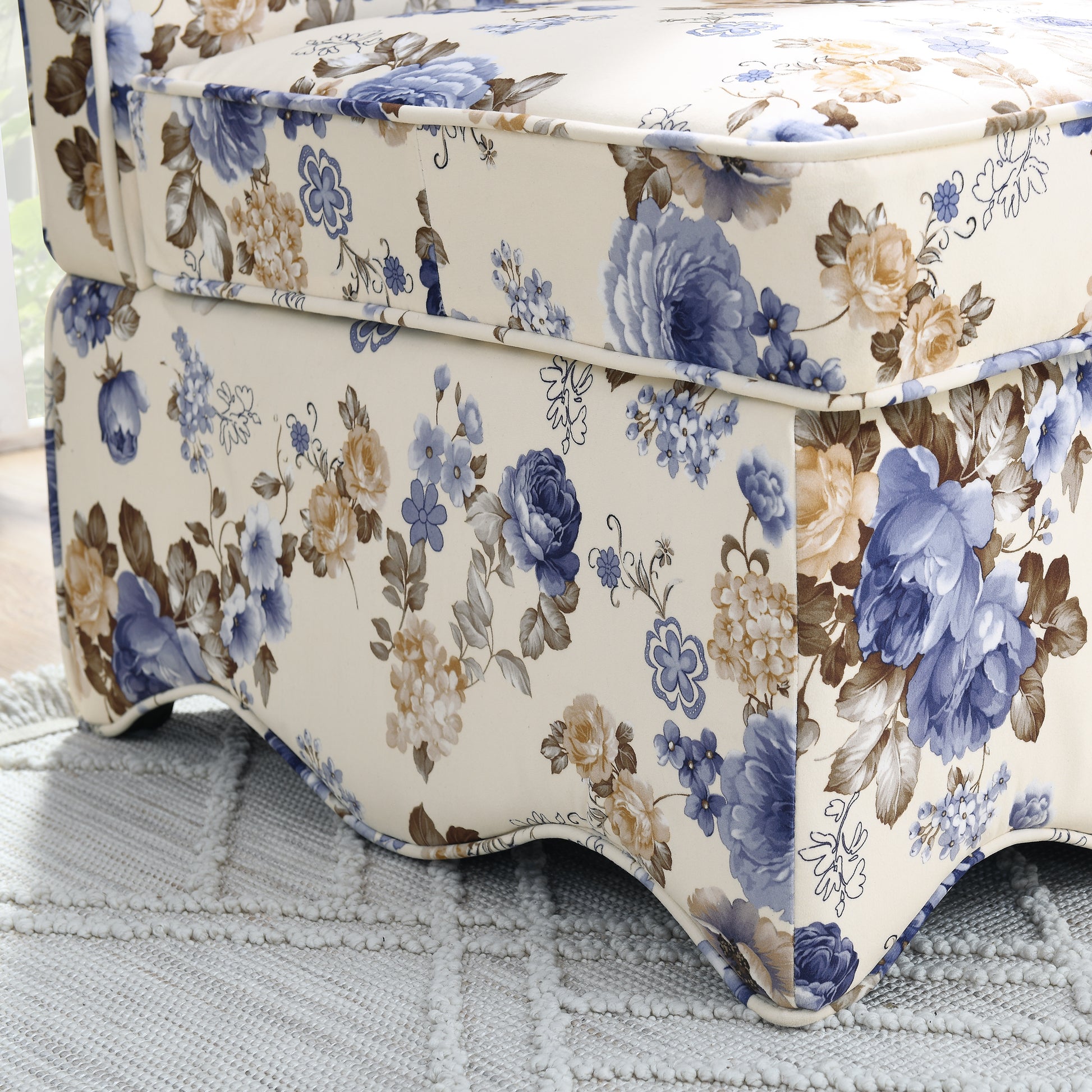 Closeup of a plush floral armchair with blue and cream roses perfect for classic home decor