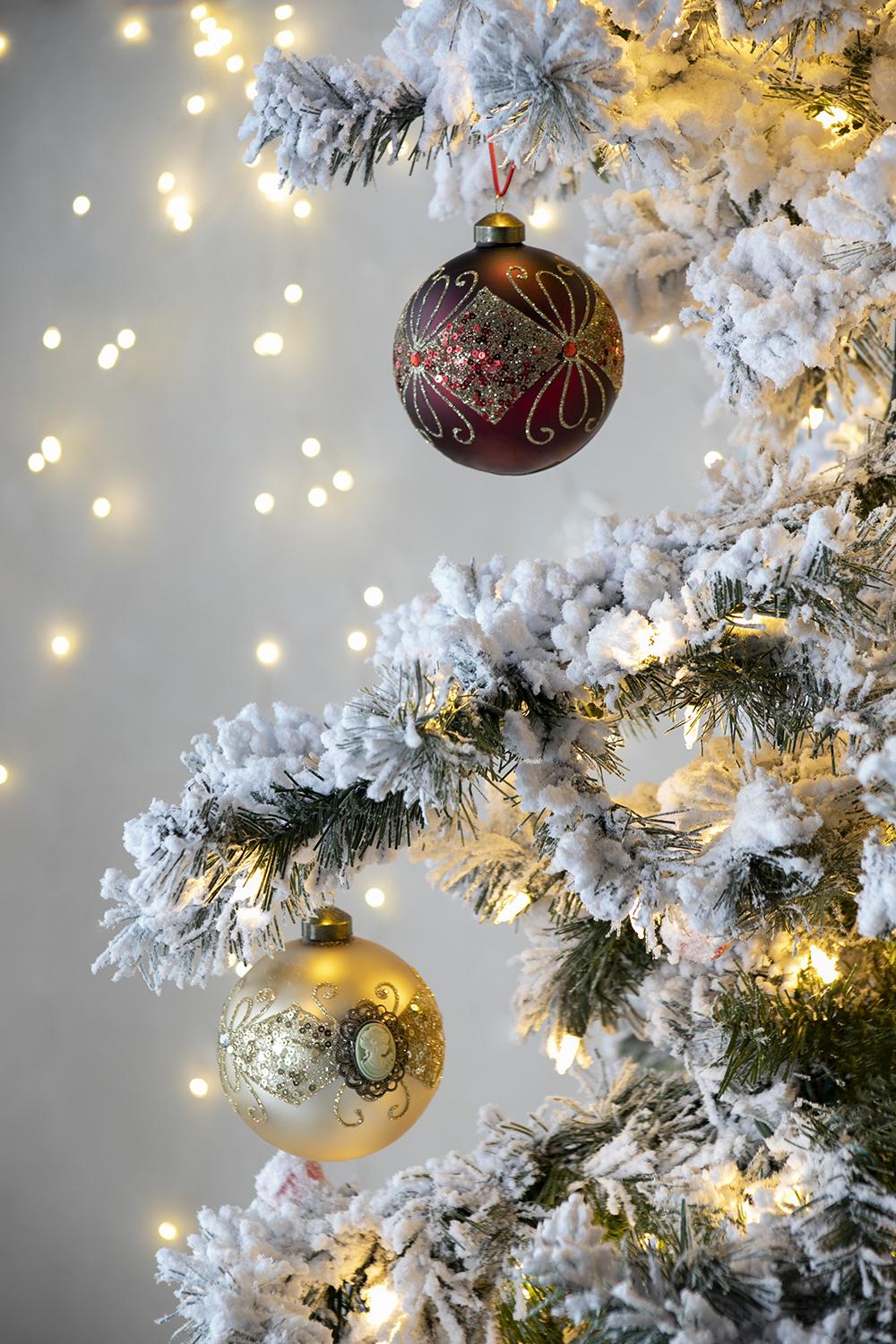 Glittery maroon Christmas ornament with ornate gold swirl design and sequin accents