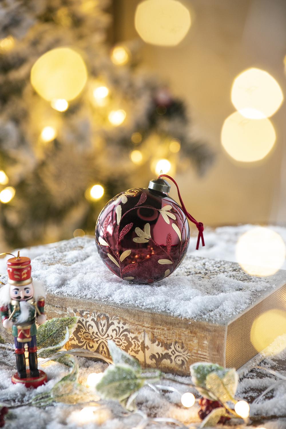 Burgundy glass Christmas ornament with gold leaf design perfect for festive tree decoration