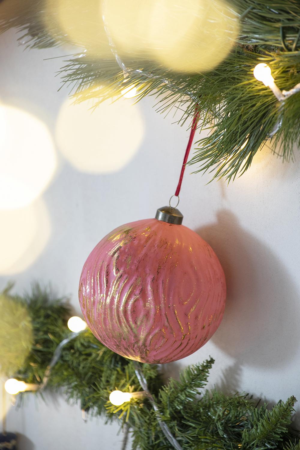 Pink textured Christmas bauble with gold accents perfect for festive tree decoration