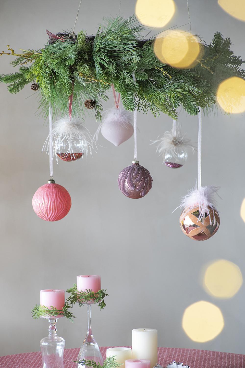 Pink textured bauble with fir garland and festive ornaments for holiday decor