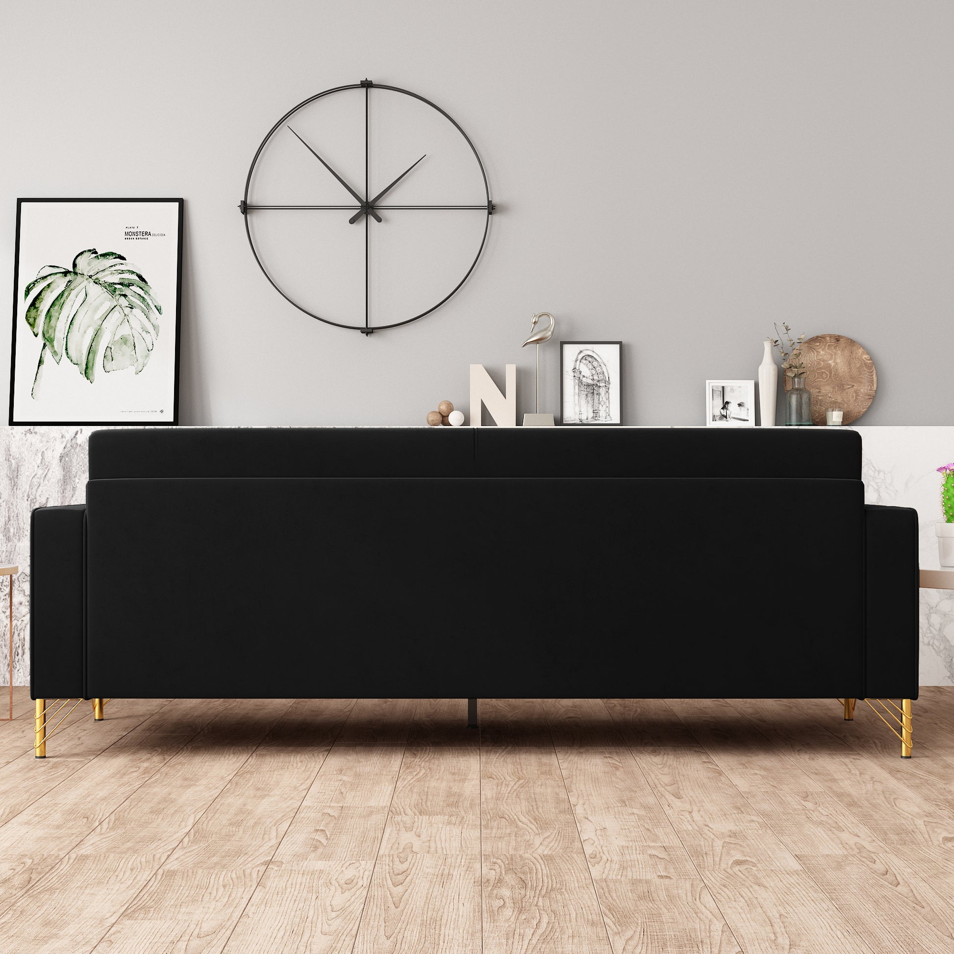 Sleek black velvet sofa with elegant gold hairpin legs perfect for modern living rooms