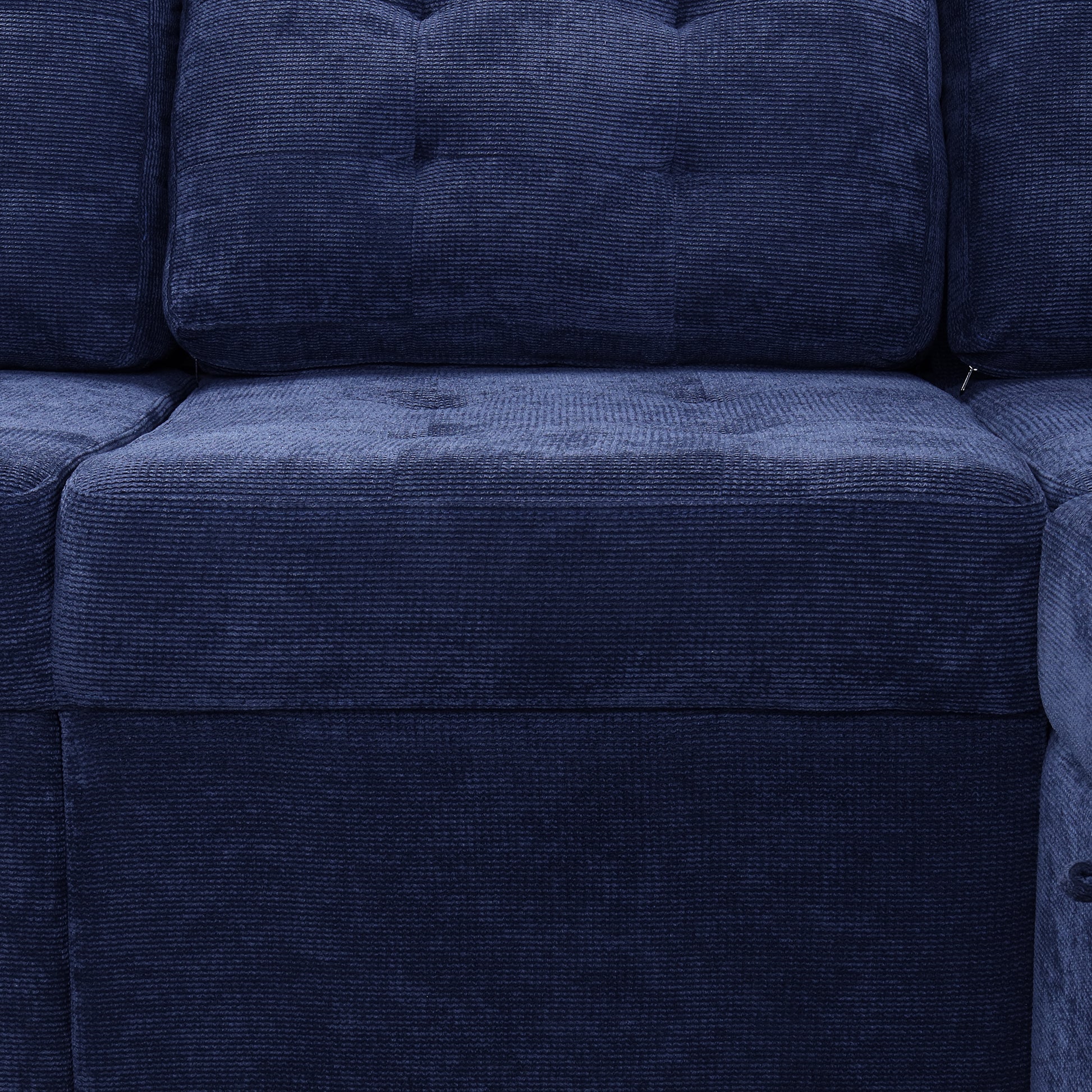 Closeup of deep blue corduroy sofa upholstery with button tufting on back cushion