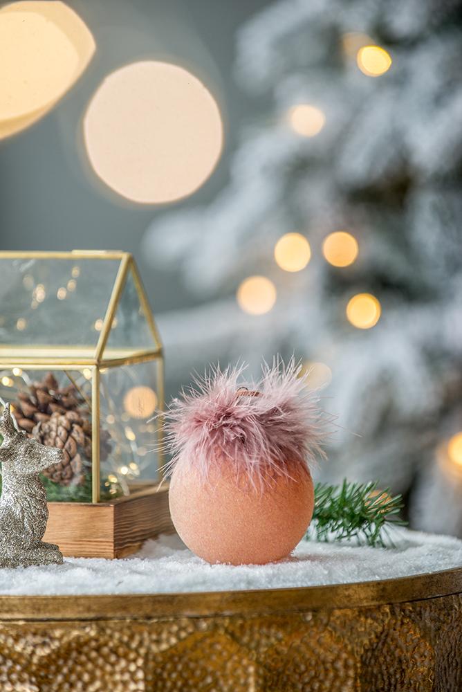 Fluffy pink Christmas bauble with textured finish nestled in faux snow