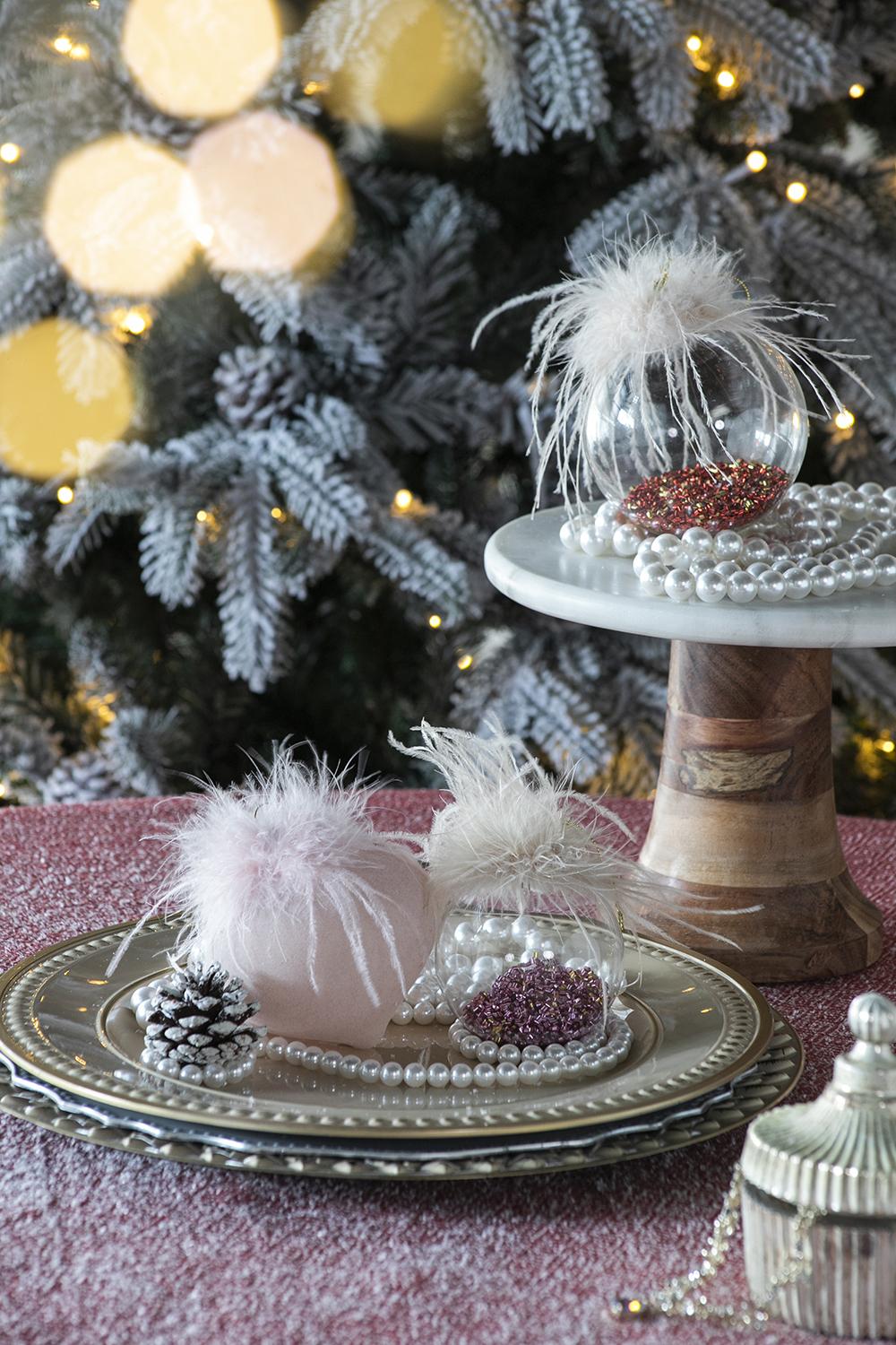 Festive Christmas ornaments with feathers and pearl beads on a festive table setting