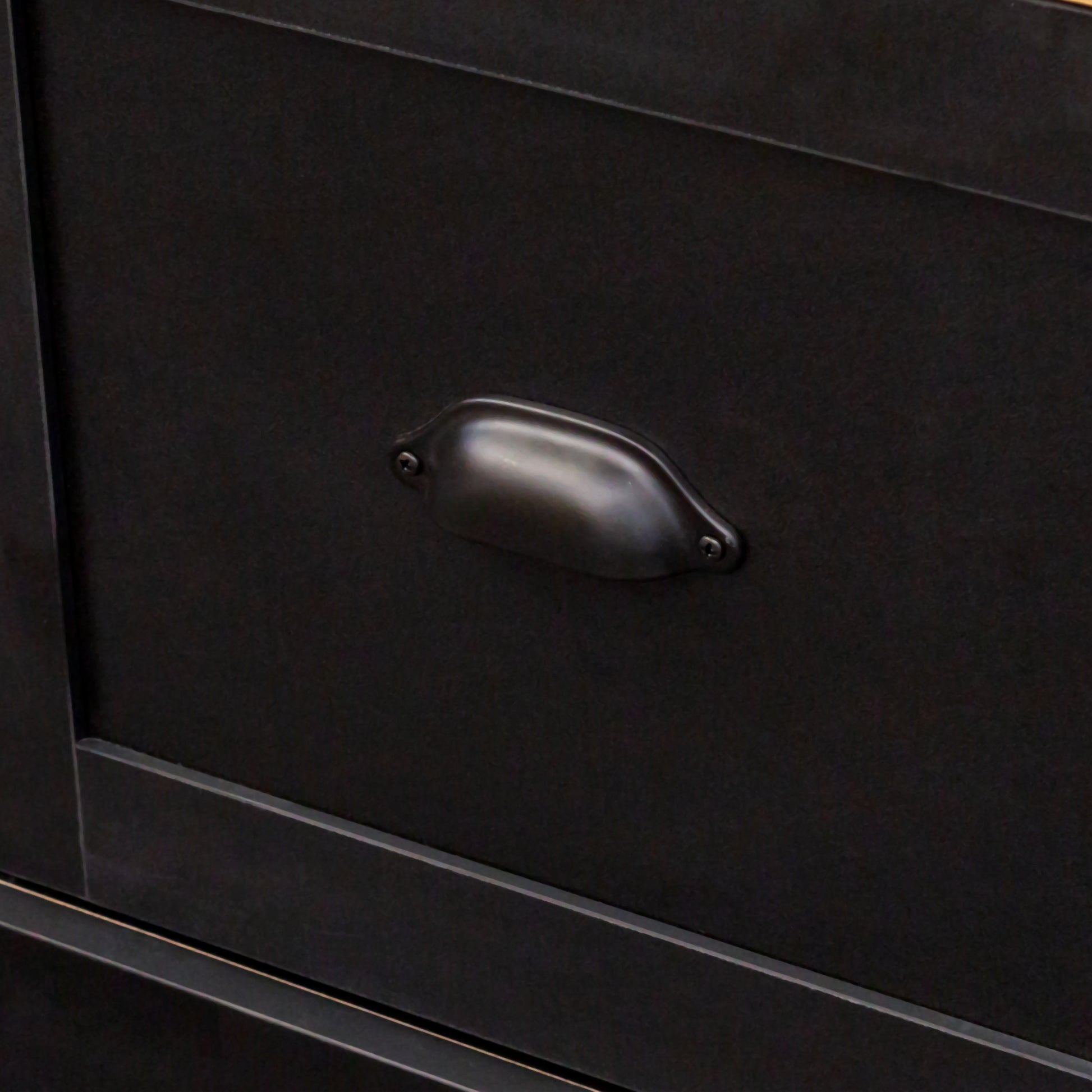 Black metal drawer pull on a dark cabinet vintage industrial style