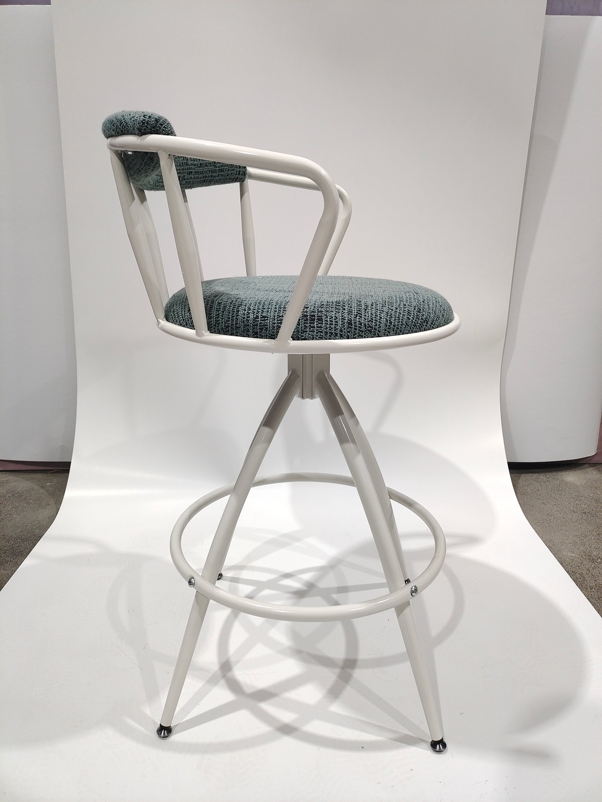 White metal swivel stool with dark teal textured seat and backrest for kitchen island
