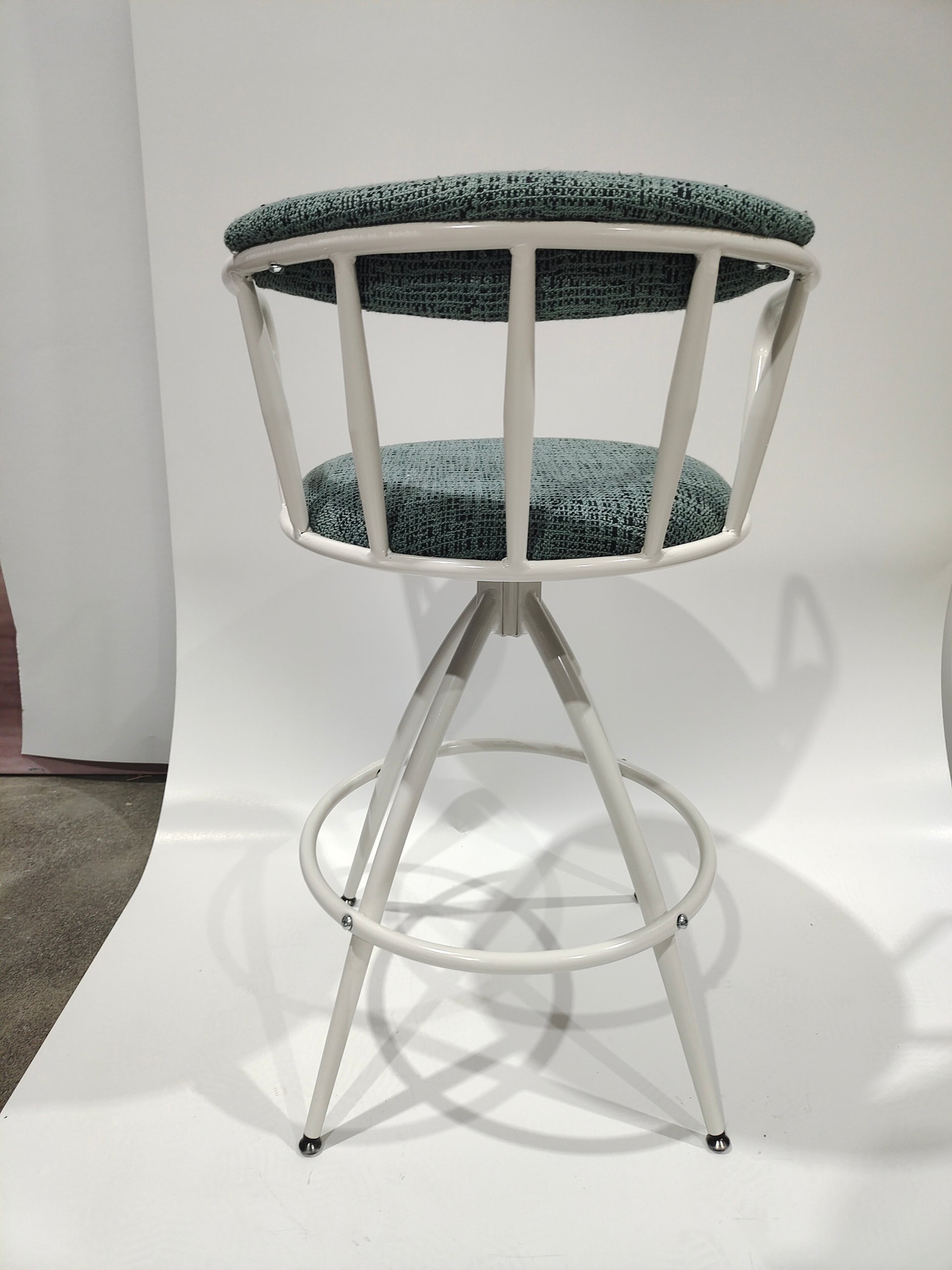 Sage green upholstered white metal swivel bar stool with crisscross back detail