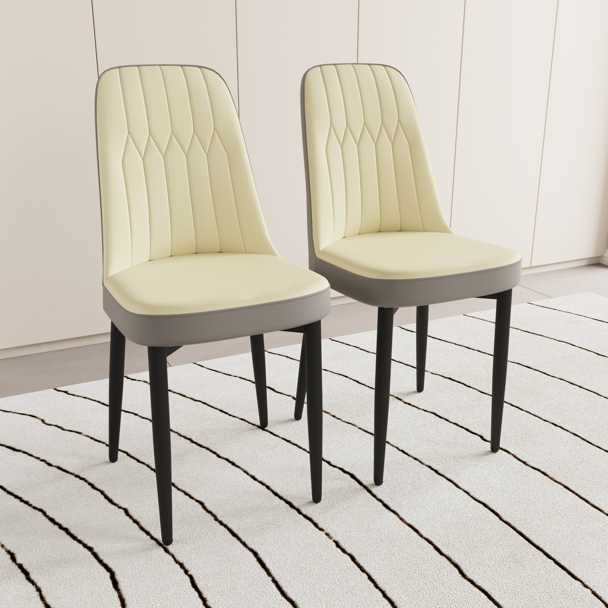 Two cream upholstered dining chairs with diamond stitching and grey trim