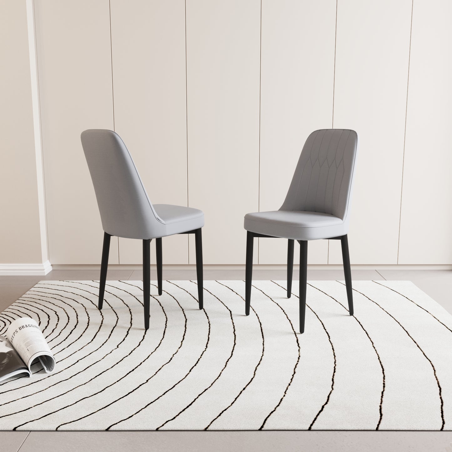 Two grey upholstered dining chairs with black legs on a black and white striped rug