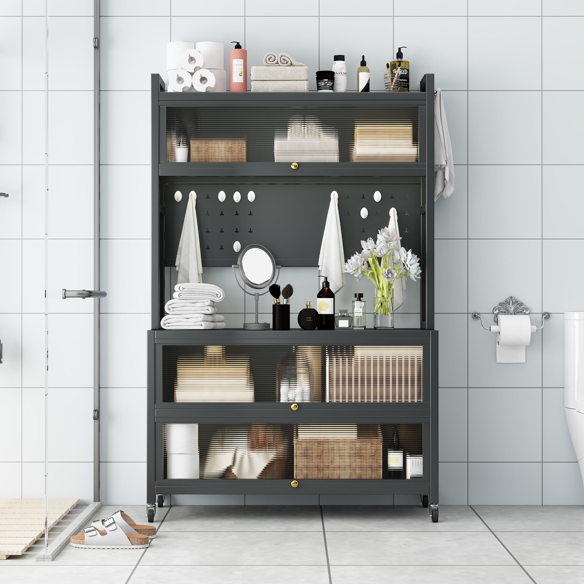 Dark grey metal bathroom shelving unit with clear ribbed glass doors and gold hardware