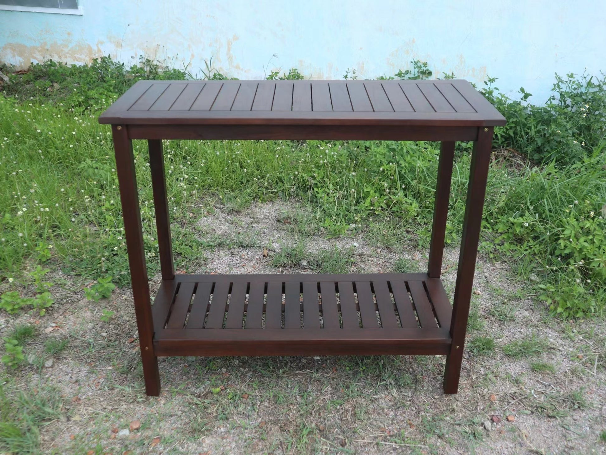 Dark brown slatted wood console table with two shelves perfect for outdoor decor