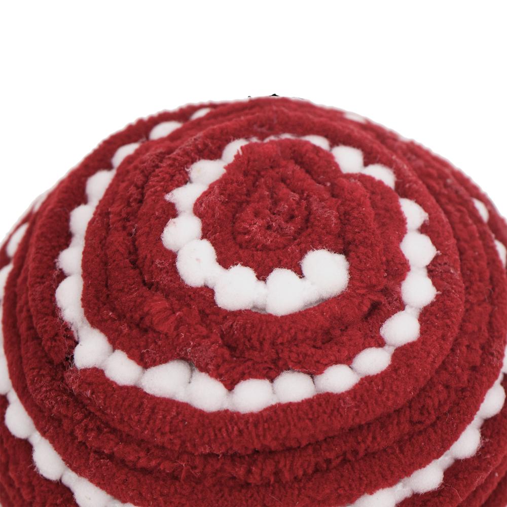 Closeup of textured red yarn ball with white pompom trim