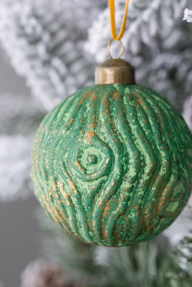 Textured green Christmas ornament with gold accents perfect for festive tree decor
