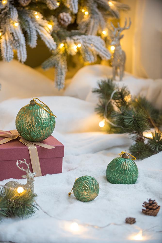 Textured green and gold Christmas bauble part of holiday decor collection