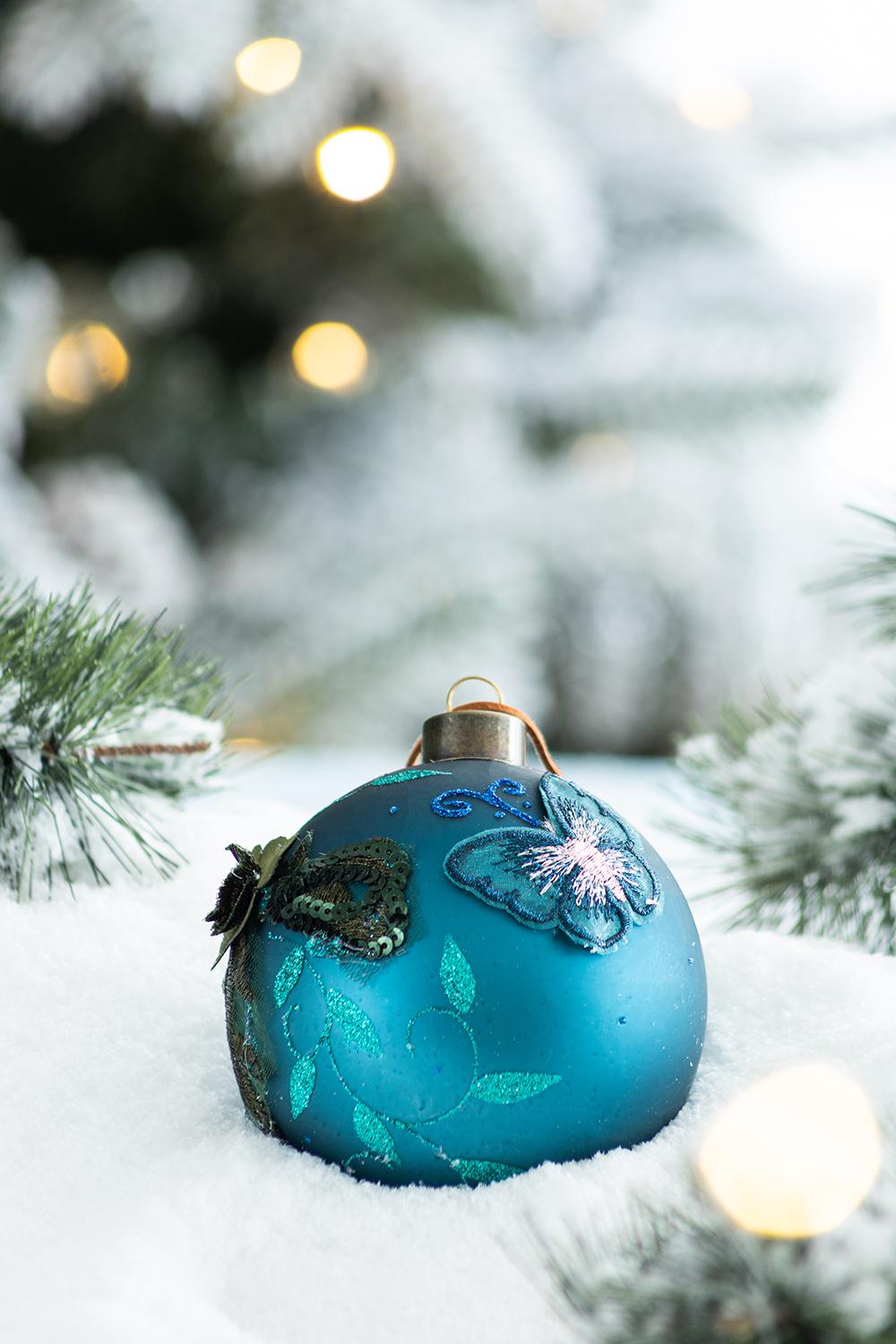 Teal glass Christmas ornament with embroidered butterfly and floral details