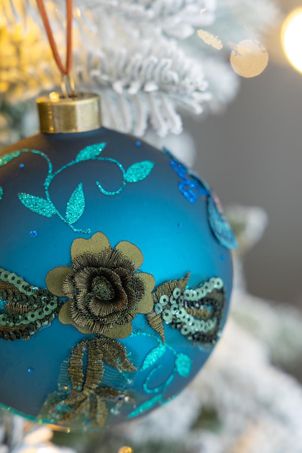 Teal glass Christmas ornament with embroidered floral details and sequins