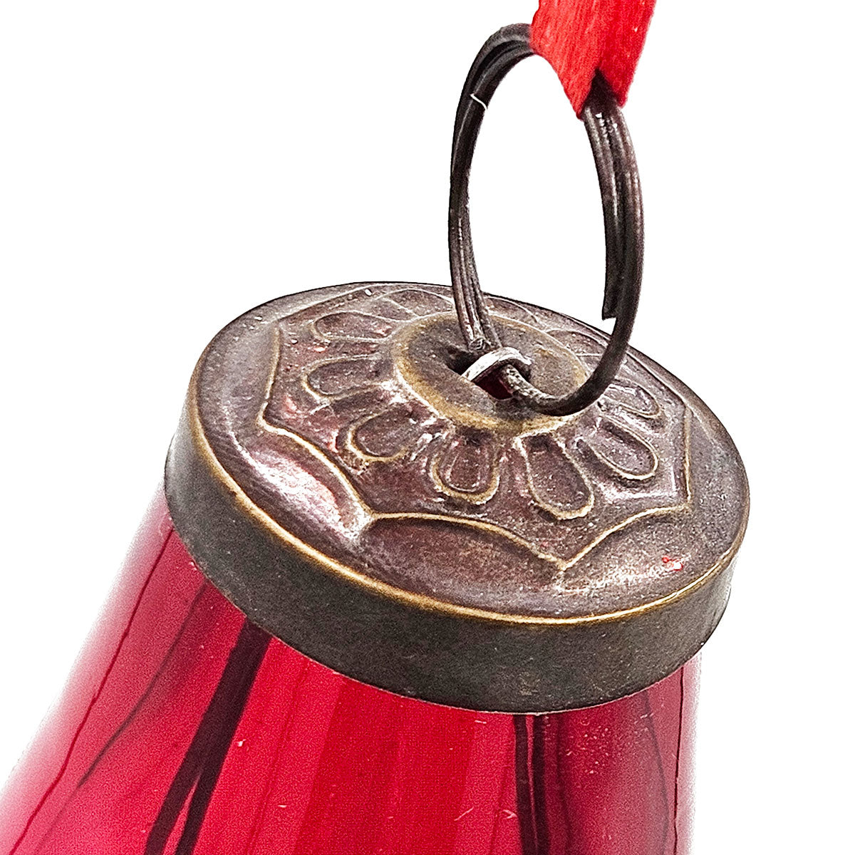 Antique brass finial on a glossy red glass Christmas ornament with ornate detailing