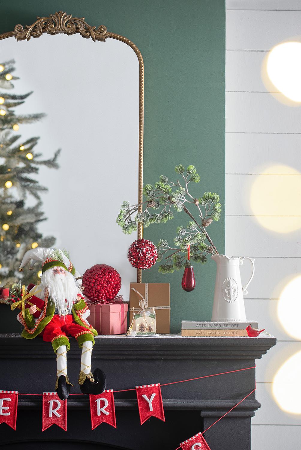 Dressed elf figure in green and red outfit holding a gift box a festive Christmas decoration