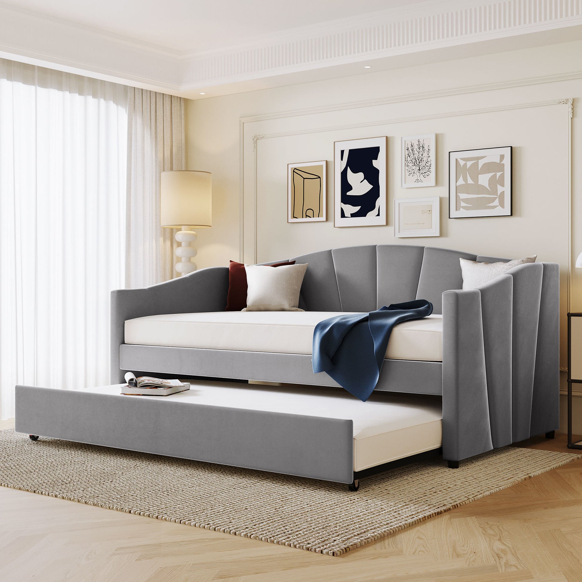 Modern grey upholstered daybed with a pullout trundle perfect for guest rooms