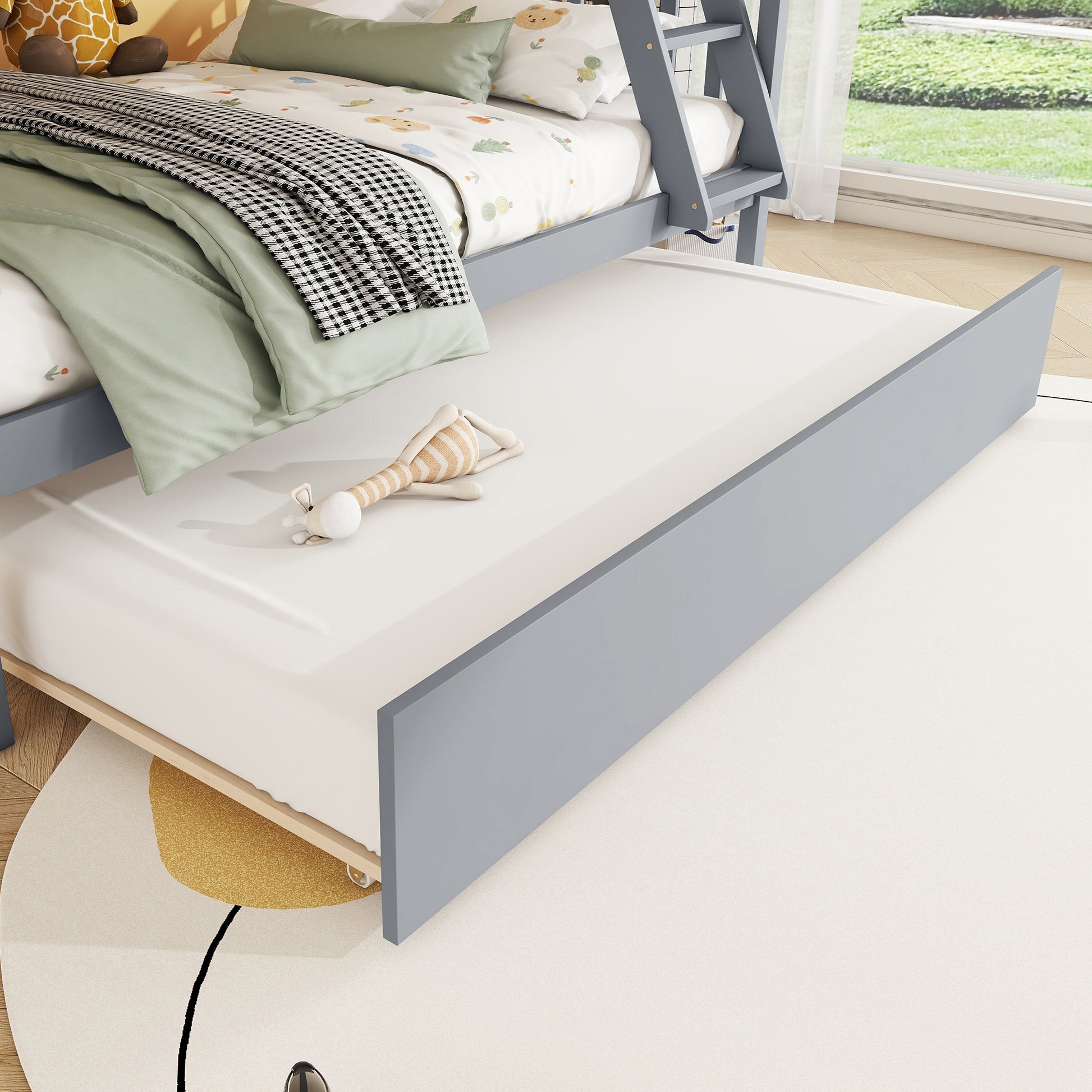 Grey wooden bunk bed trundle pulled out with a stuffed toy