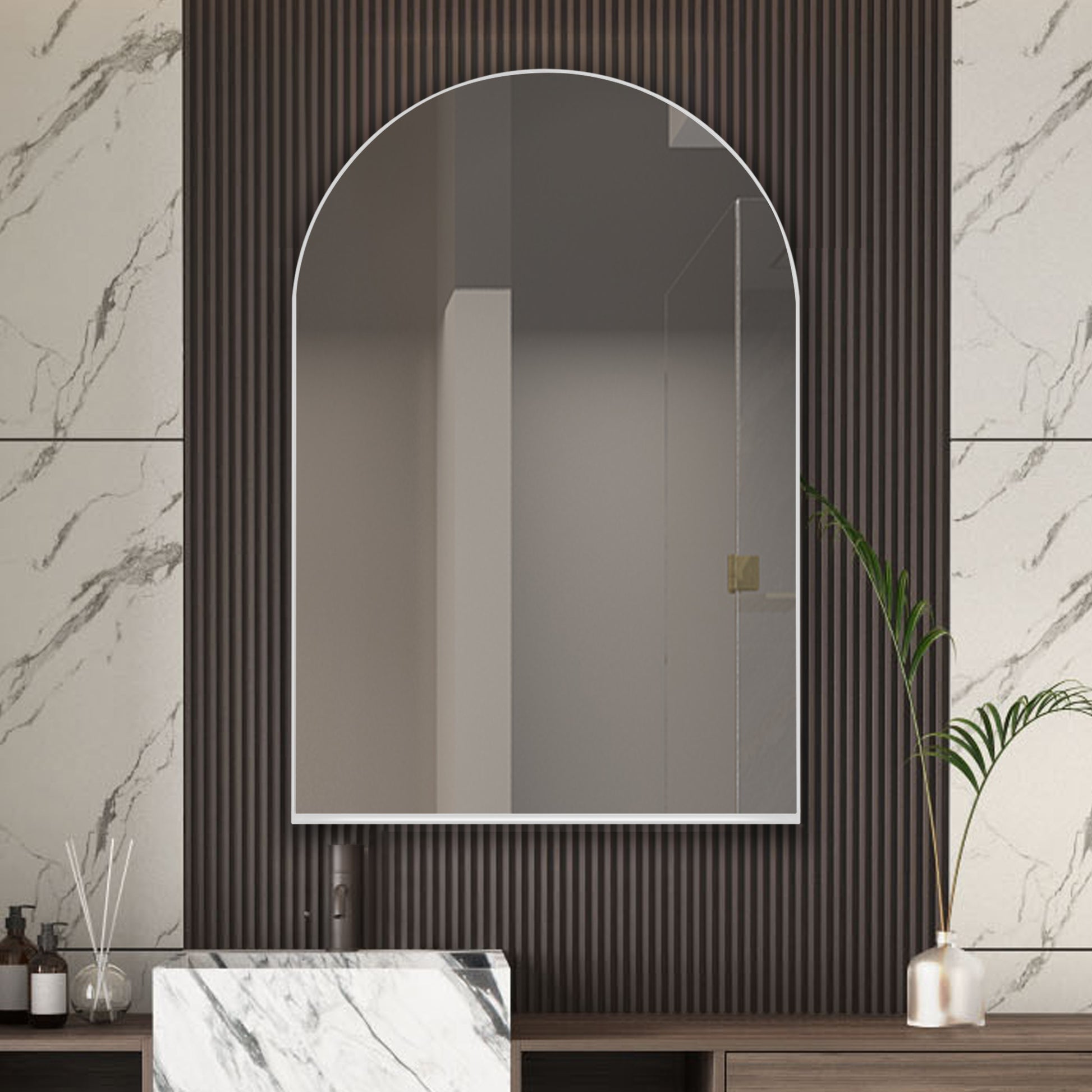 Arched frameless bathroom mirror with marble and wood paneling background