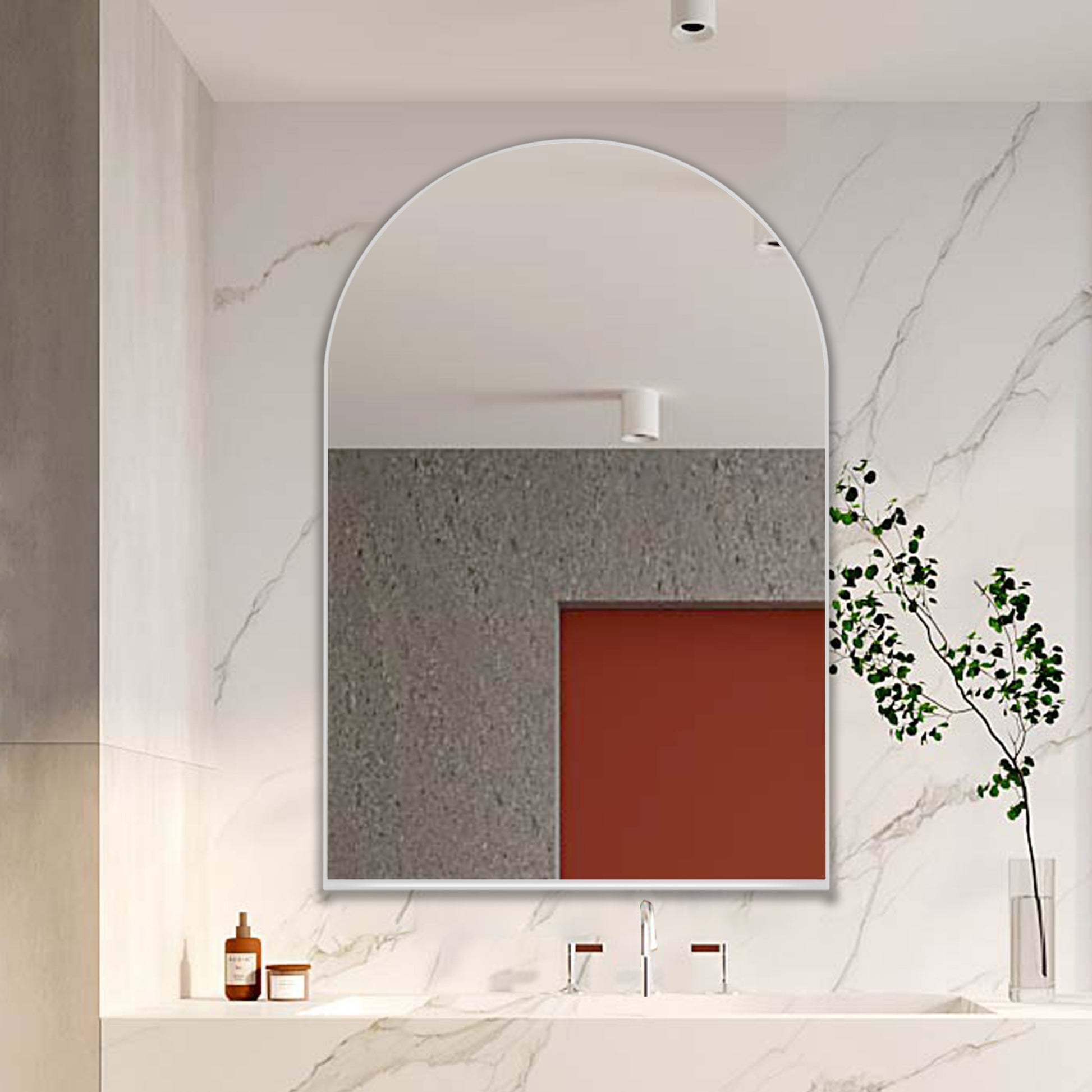 Arched modern bathroom mirror with a thin silver frame complementing a marble vanity