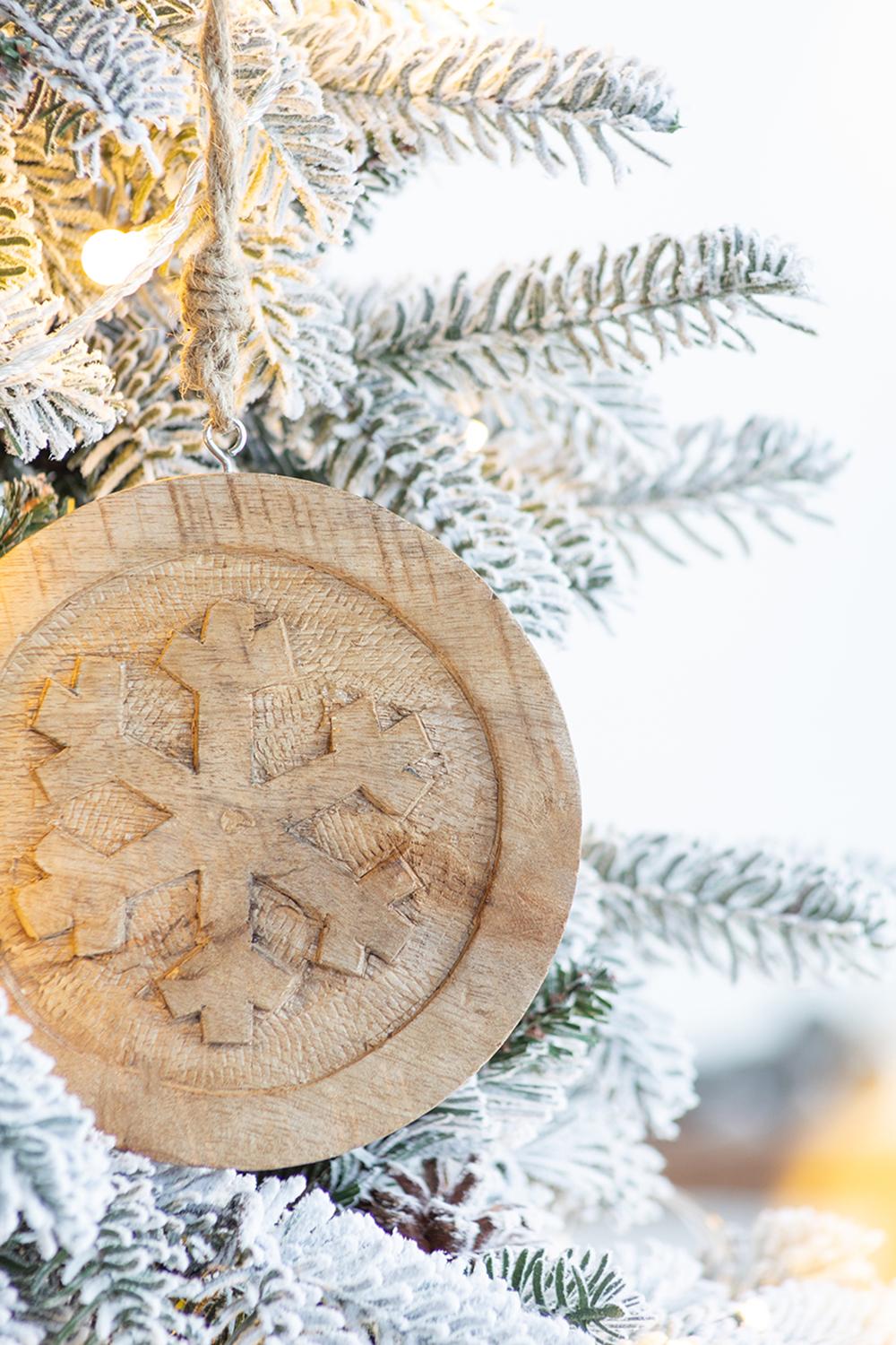 Carved wooden snowflake ornament with rustic twine perfect for festive decor