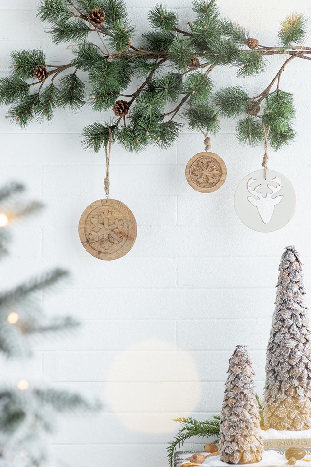 Wooden snowflake ornament hanging on pine branch festive Christmas decor