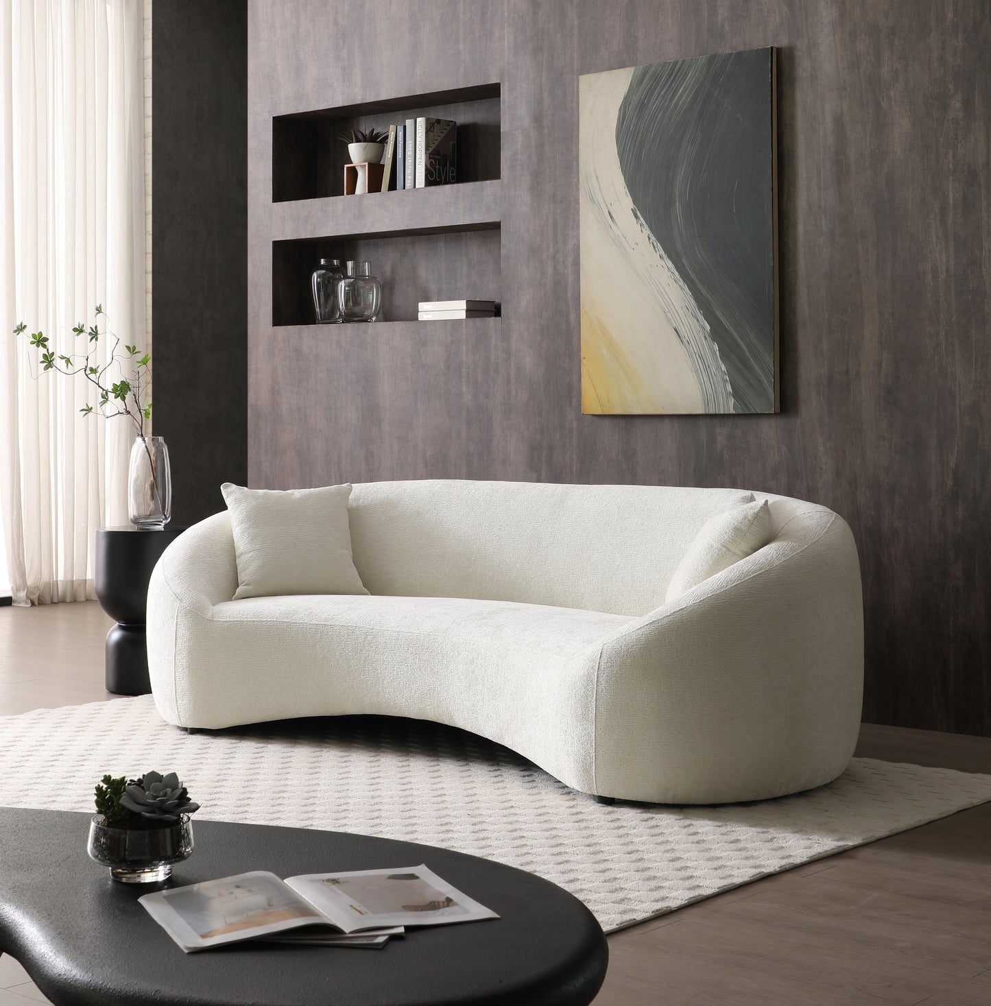 Curved boucle sofa in ivory with a matching throw pillow perfect for modern living rooms