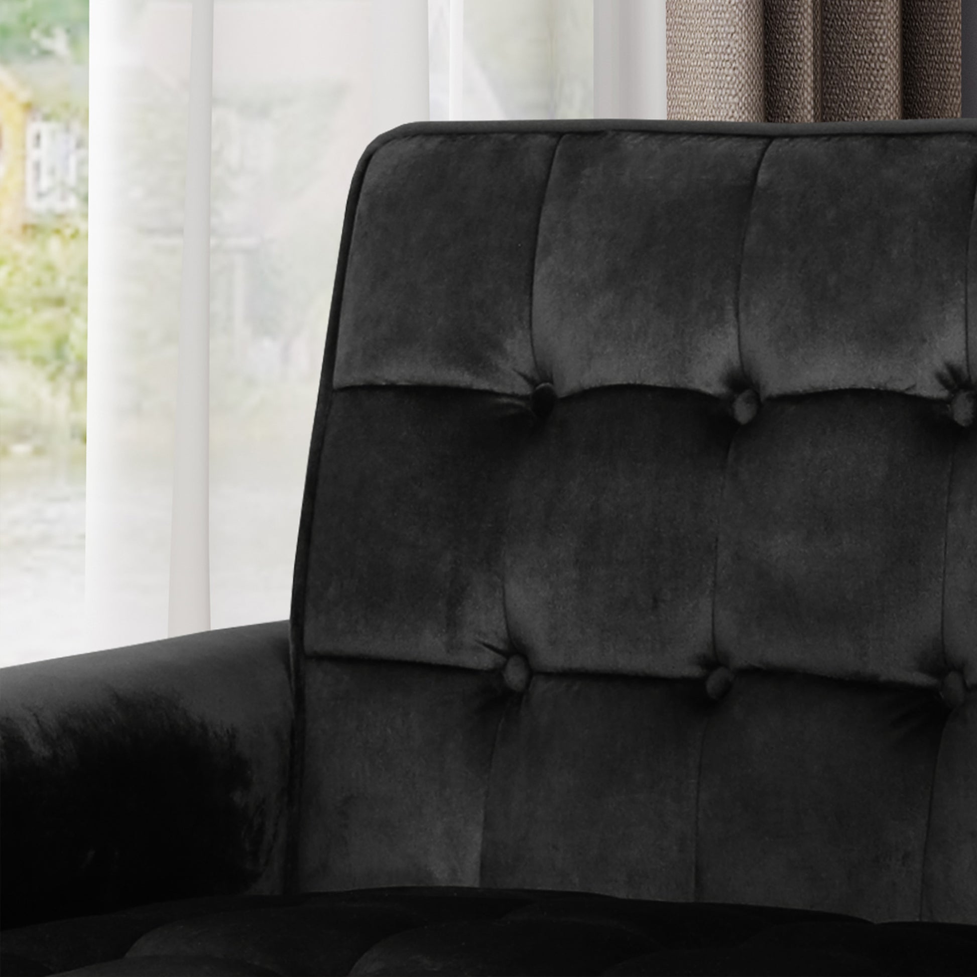 Black velvet armchair with deep button tufting and plush cushions