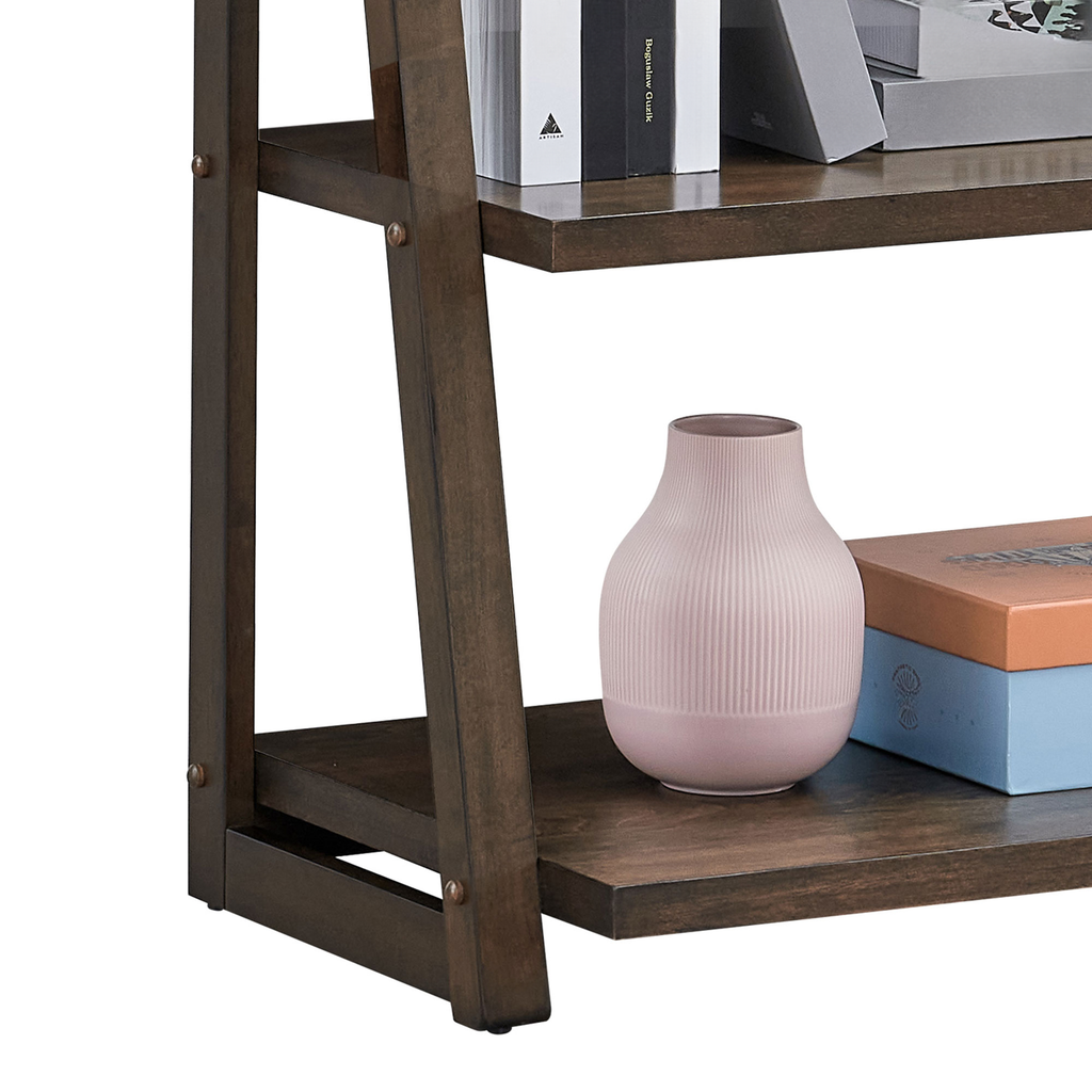 Dark brown wooden ladder shelf with ribbed pink vase and stacked decorative boxes