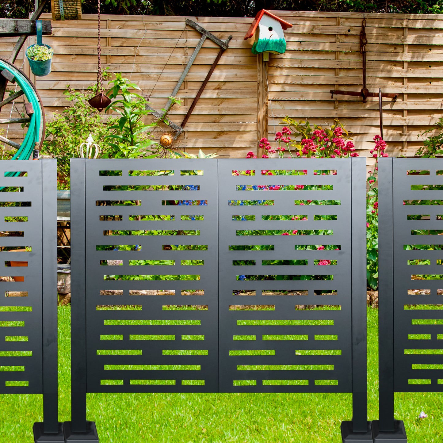 Modern dark gray metal garden privacy screen with geometric cutouts