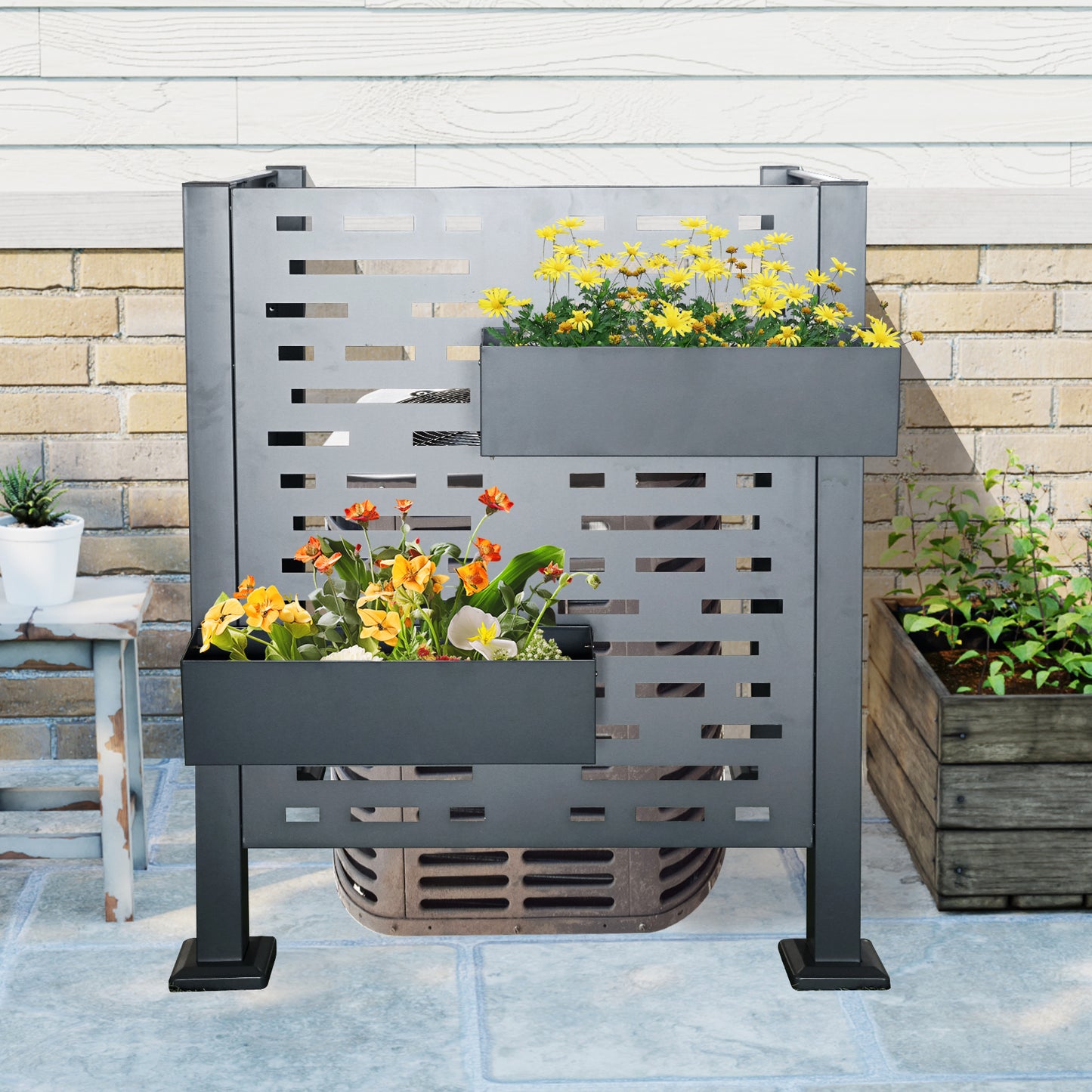 Modern gray metal outdoor air conditioner screen with two planters filled with yellow and orange flowers