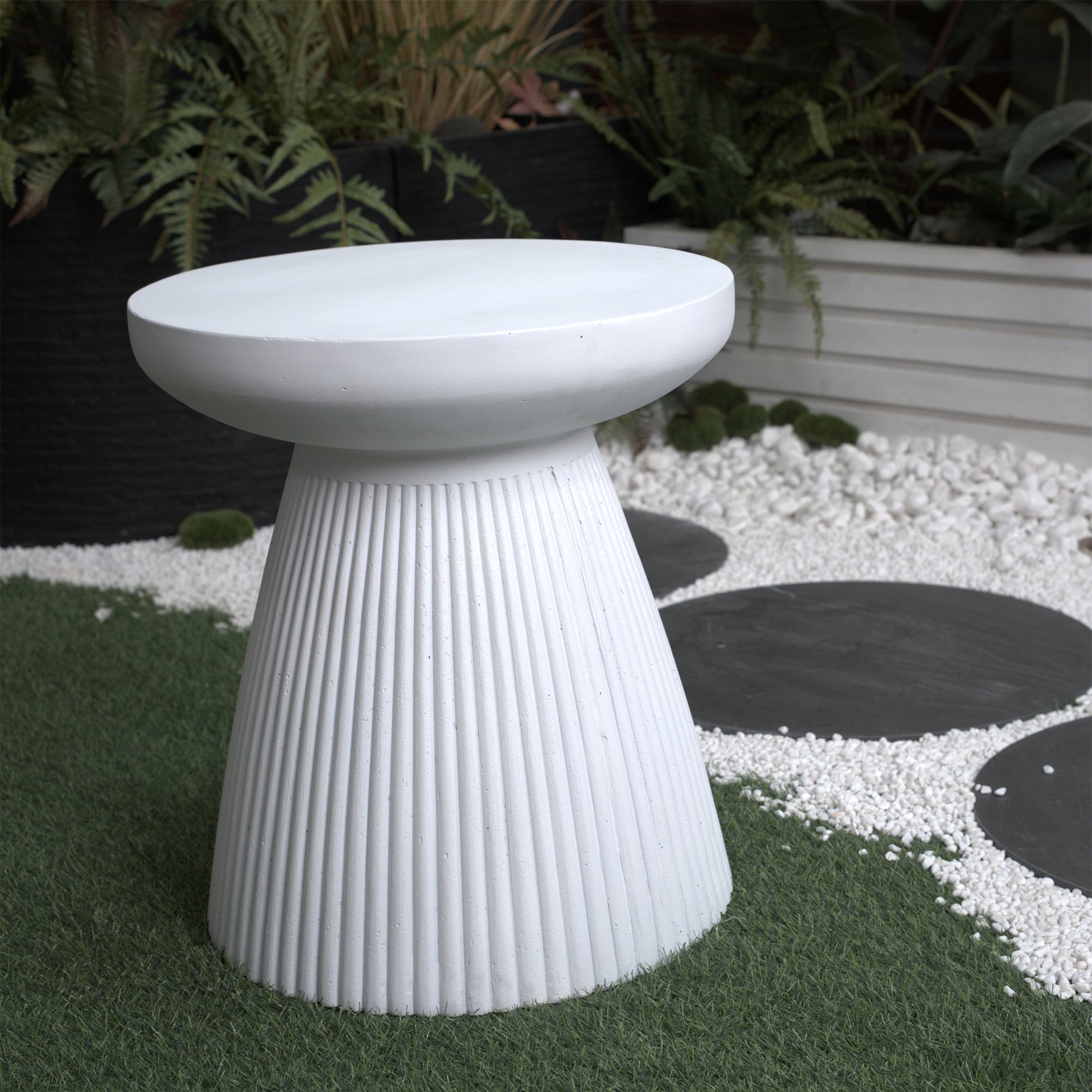 Fluted white ceramic side table with a mushroom silhouette perfect for outdoor seating areas