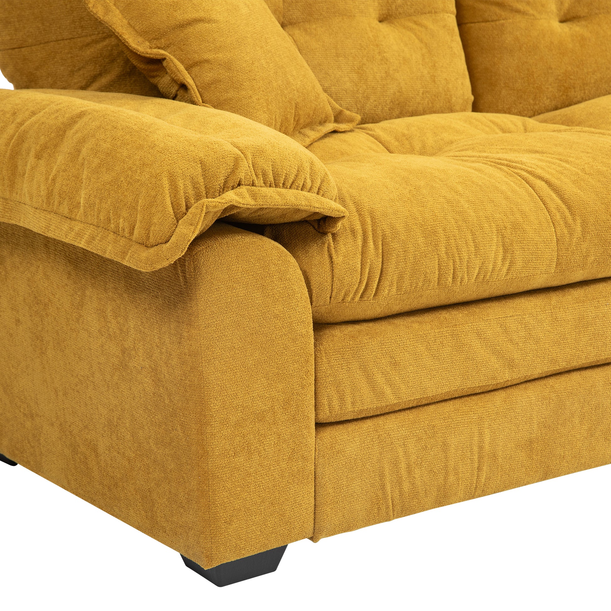 Closeup of a plush mustard yellow sofa armrest with textured fabric upholstery